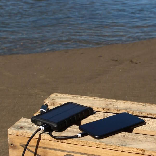 SunSaver 10K power bank charging phone at estuary