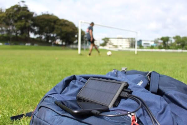 SunSaver 10K power bank charging phone & playing soccer